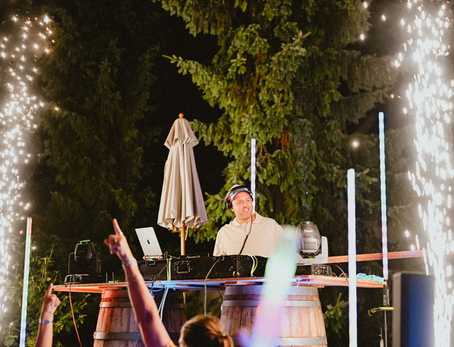 DJ XAM inmitten einer abendlichen Show mit Pyrotechnik und stilvollem Bühnenaufbau
